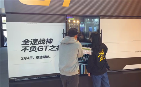 展会现场体验者使用摩拓为手动透明滑轨屏了解产品